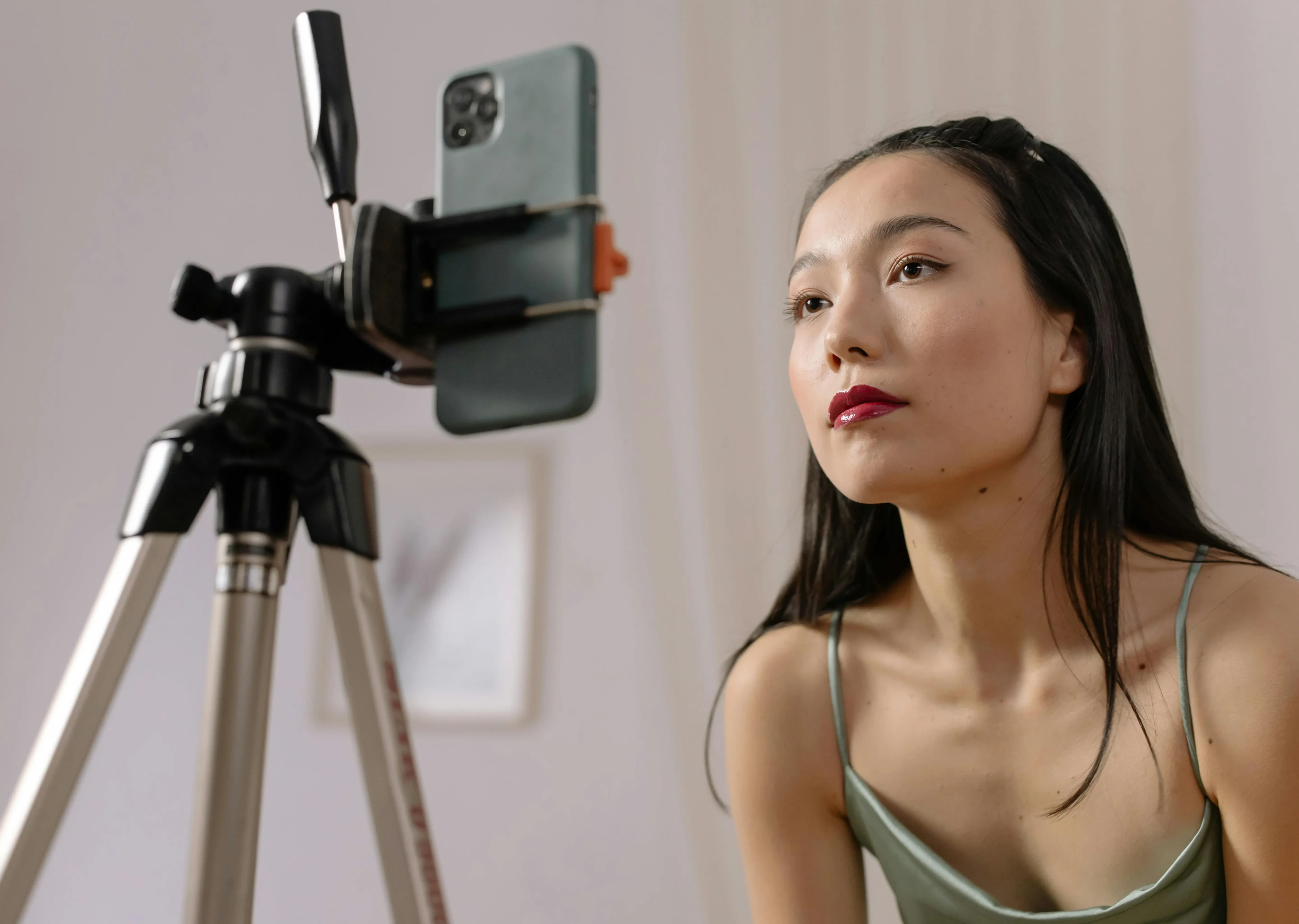 An influencer posing in front of a camera on a tripod